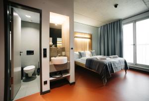 柏林罗西酒店的一间卧室配有床和水槽,还有一间浴室