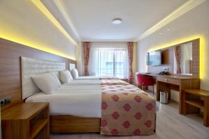 博卢Bolu Suit Otel的酒店客房设有一张大床和一张书桌。