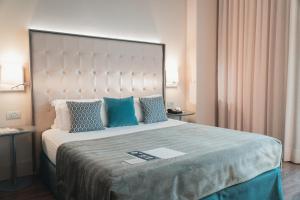 巴塞罗那Gran Hotel Havana 4Sup by Escampa Hotels的一间卧室配有一张带蓝色枕头的大床