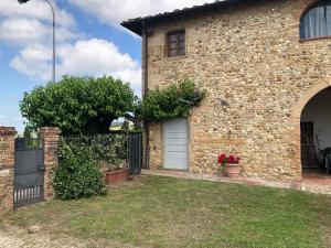 马西亚拉Casa di Romano, Al Tramonto的砖屋,有白色的门和栅栏