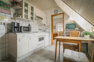 索尔陶Boer的厨房配有白色橱柜和木桌
