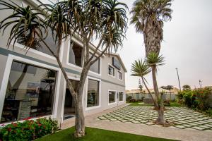 斯瓦科普蒙德Sea View Bliss Guesthouse with self Catering的前面有棕榈树的房子