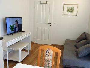 克拉根福215 Apartment Wien 4-6 Pers 42m2的客厅配有沙发和书桌上的电视