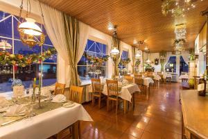 费尔德伯格戴安娜酒店的餐厅设有白色的桌椅和窗户。