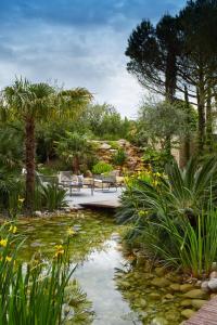 瓦朗斯皮克住宅酒店的花园,花园内有池塘、长椅和植物