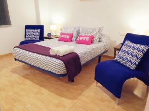 瓦伦西亚Central Apartment in Valencia with WIFI + Parking.的一间卧室配有一张床和两张蓝色椅子