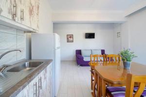斯卡拉卡里拉奇斯Sevastiani’s Apartments的厨房配有冰箱和桌椅