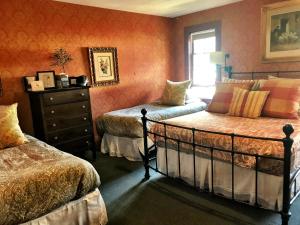 史凯威Historic Skagway Inn的一间带两张床和梳妆台的卧室