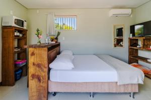 瓜尔达恩巴Pousada Container Eco Guarda的一间卧室配有一张带白色床单的大床
