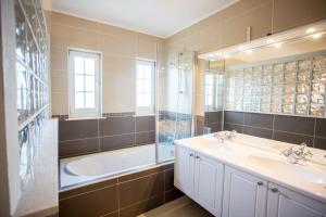 帕科坦Villa Lena的浴室配有2个盥洗盆、浴缸和淋浴。