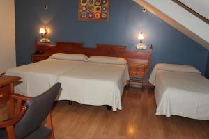 蓬费拉达埃尔卡斯特洛酒店的一间卧室配有两张床、一张桌子和一把椅子