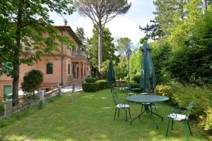 AmandolaVilla delle Rose - Hotel Paradiso的院子里的桌椅和遮阳伞
