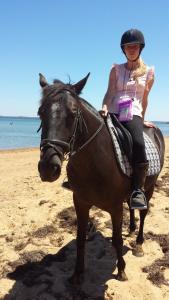 巴斯巴斯海岸乡村别墅住宿加早餐旅馆的一位妇女在海滩上骑马