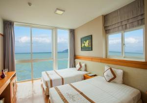 芽庄龙竹酒店的酒店客房设有两张床和大窗户。