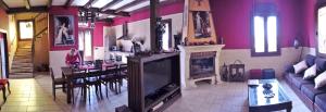 El RobledoCasa Rural La Alcazaba的带电视的客厅和用餐室