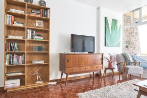 比勒陀利亚House Sandrock Muckleneuk Selfcatering apartment的客厅设有电视,位于木制娱乐中心