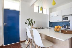 比勒陀利亚House Sandrock Muckleneuk Selfcatering apartment的厨房配有白色的柜台和蓝色的门