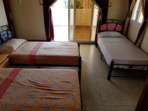 Tan-Tan PlageHotel Canarias Sahara的窗户间里设有三张床