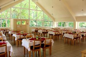 巴拉顿城堡BF酒店 的餐厅设有桌椅和窗户。