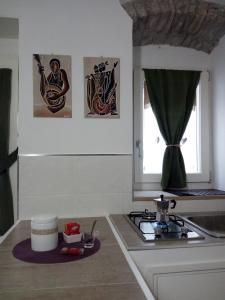 RoccamandolfiB&B Il Buon Cammino的厨房配有炉灶,墙上挂有图片