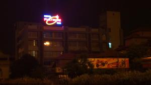 艾哈迈达巴德白金酒店的一座晚上有 ⁇ 虹灯标志的建筑