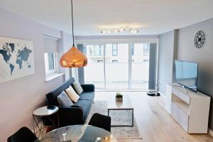 伦敦2BR/2Bath Luxury Modern Flat in the City London的客厅配有蓝色的沙发和玻璃桌