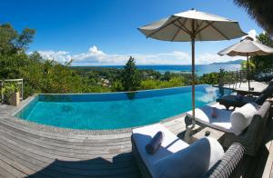 拉迪格岛乐德麦尼得劳昂吉瑞尔度假村和Spa的一个带两把椅子和遮阳伞的游泳池
