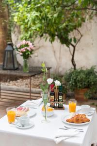 塞维利亚阿尔坎塔拉酒店的一张带食物和橙汁盘的白色桌子