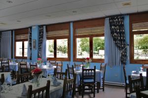 博索斯特加罗纳酒店的用餐室设有桌椅和窗户。