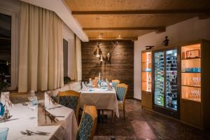 塞尔瓦迪加尔代纳山谷罗德拉酒店的用餐室配有桌椅,酒窖
