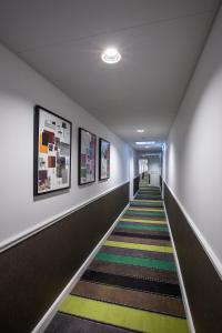 哥本哈根阿布萨隆丹恩斯克食客酒店的走廊上设有长长的楼梯,墙上挂有绘画作品