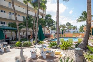 劳德代尔堡温宅穆海滩俱乐部度假公寓的一个带游泳池和棕榈树的度假村