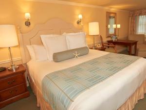 海恩尼斯Anchor In Hotel - Hyannis, MA的一间卧室配有一张大床和两盏灯