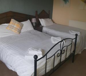 安南昆斯伯里阿姆斯酒店的卧室内的两张床,配有白色床单和枕头