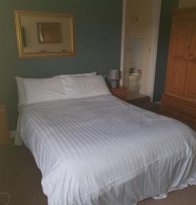安南昆斯伯里阿姆斯酒店的卧室内的一张大白色床,带浴室