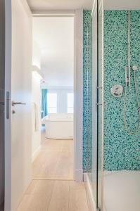 马贝拉L'Ocean Penthouse Banus的浴室配有带浴缸的玻璃淋浴间