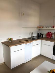 曼海姆Feel-Good Apartment In Mannheim-Neckarau的厨房配有白色橱柜和水槽