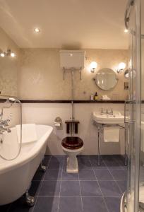 卡林福德甘楼酒店的带浴缸、卫生间和盥洗盆的浴室