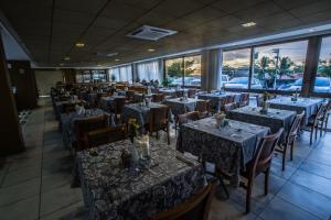 萨尔瓦多卡图萨巴商务酒店的一间设有桌椅的餐厅,位于带窗户的房间内