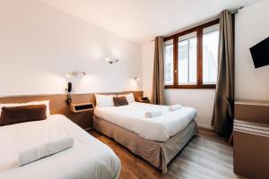 图卢兹爱丽兹酒店的一间卧室设有两张床和窗户。