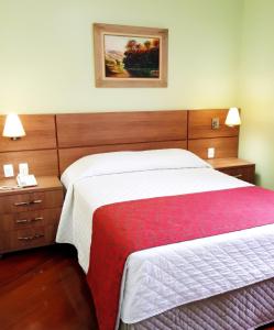 欧鲁普雷图珀萨达科拉斯卡酒店的酒店客房设有一张床,墙上挂着一张照片