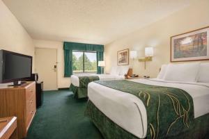 MorrillTravelodge by Wyndham Morrill的酒店客房设有两张床和一台平面电视。
