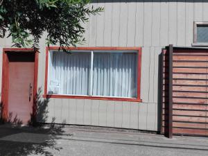 FreireQuimey Ruca的一座带窗户和红色门的建筑