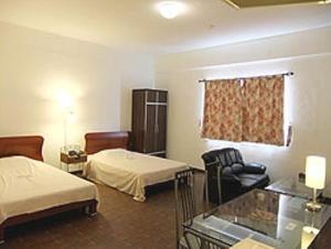 加拉班金宝殿酒店的酒店客房,配有两张床和椅子