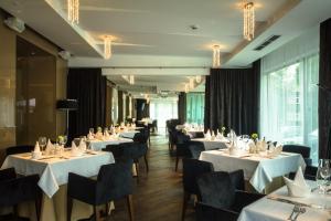 德鲁斯基宁凯德鲁斯金卡列图维Spa大酒店的餐厅的一排餐桌,配有白色桌布