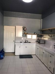 San Vicentelee's home2的一间大厨房,配有白色的橱柜和水槽