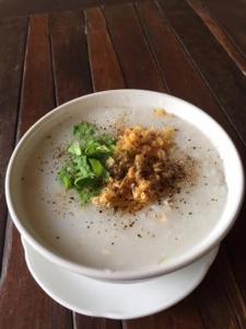 夜占县Baan Bar Cafe的木桌上一碗带西兰花的白碗食物