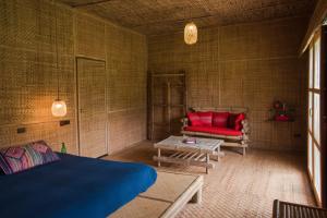 湄登丽苏旅馆的客房设有床、沙发和桌子。