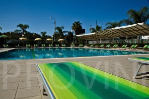莱波拉诺亚特兰堤公寓酒店的一个带椅子和遮阳伞的大型游泳池