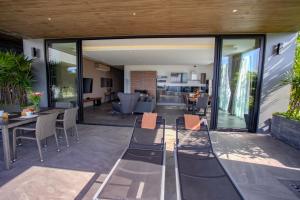 芭东海滩Ocean Rock Kalim的一个带玻璃门和椅子的庭院和一间客厅
